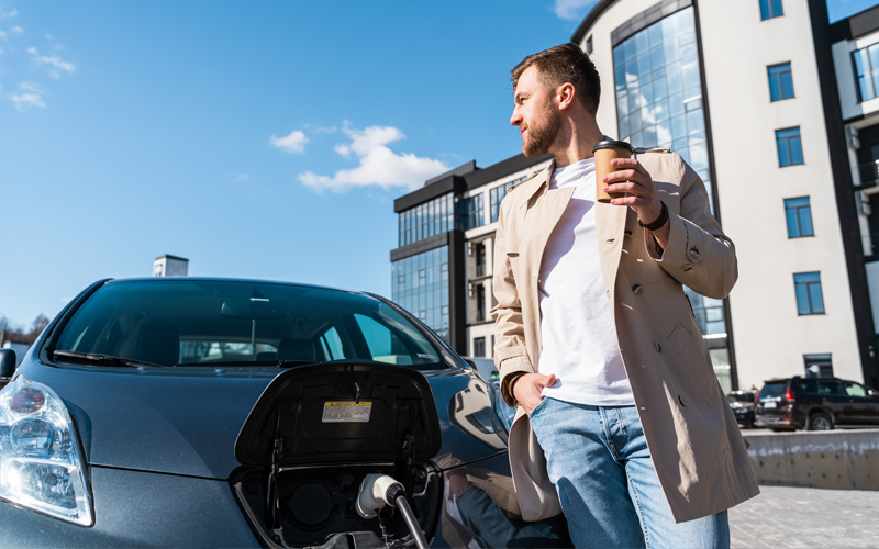 man having a break whilst charging ev