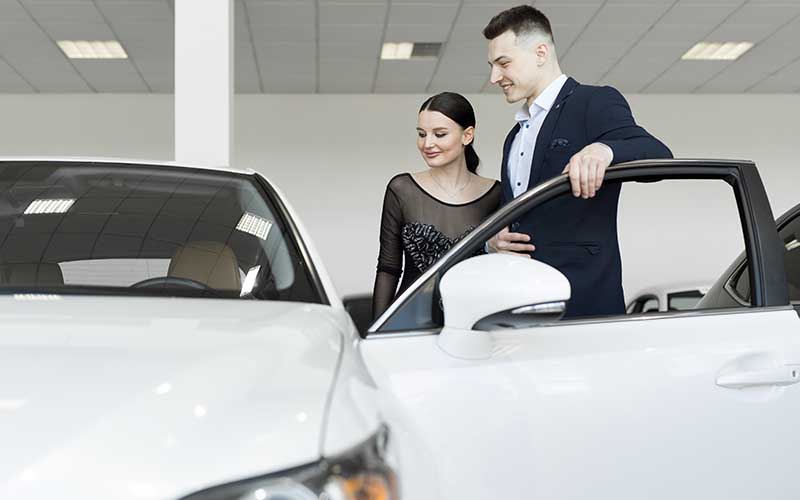 Young woman being shown a car by sales executive