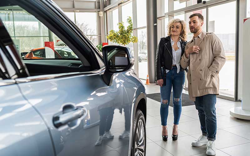 A couple browsing vehicles in a dealership