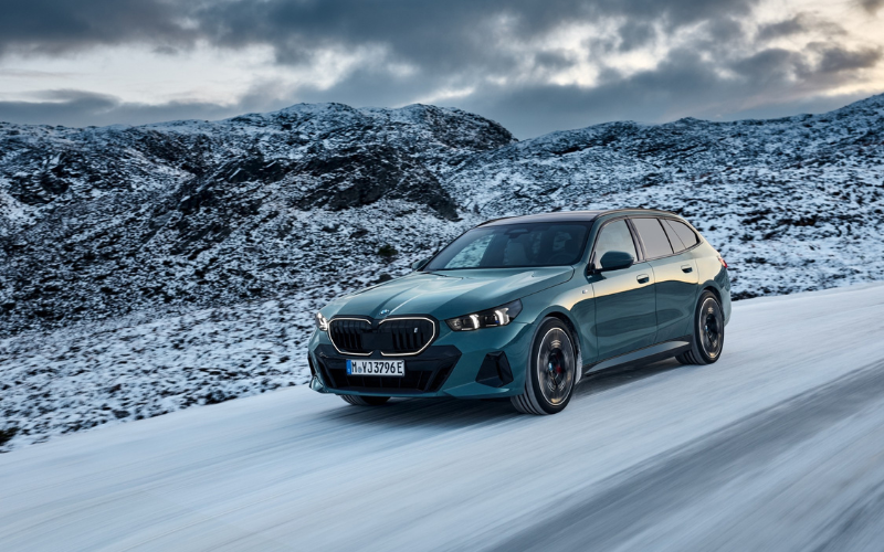 BMW X5 driving through snowy landscape