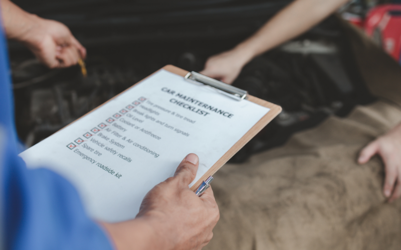 Technician holding a vehicle maintenance checklist