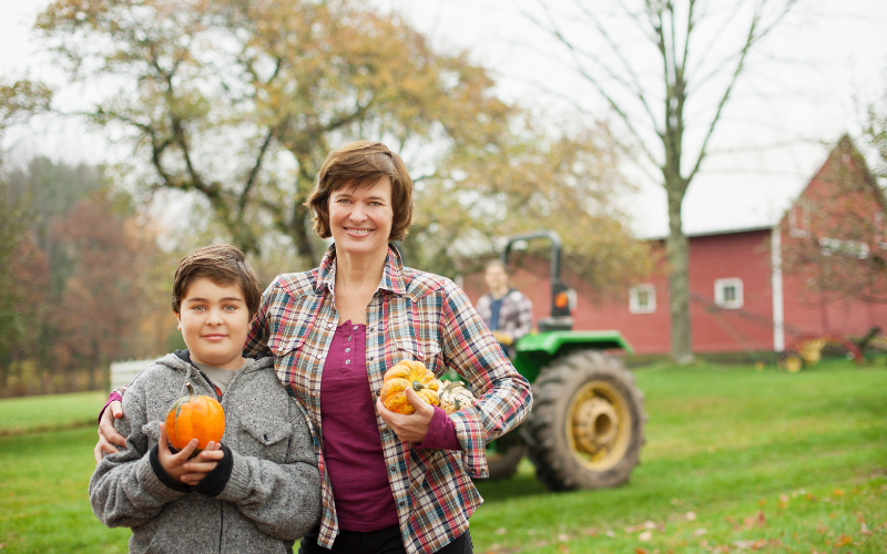 Woman and child picking pumpkins at a farm